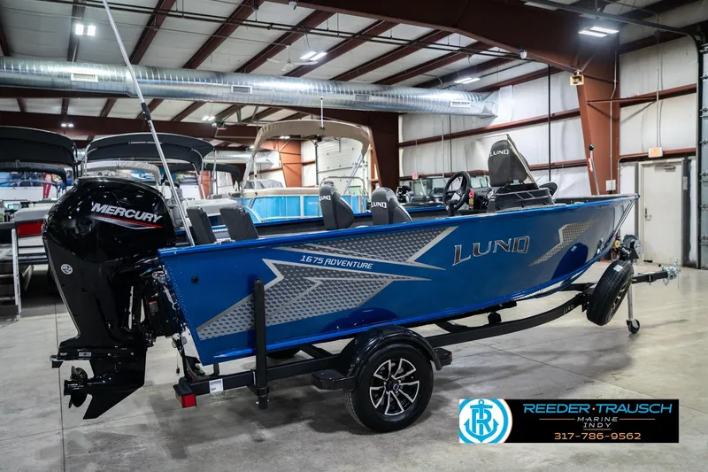 Slide: The Image of 2026 Lund 1675 Adventure SS boat in showroom, featuring Mercury engine and sleek blue design. - 6