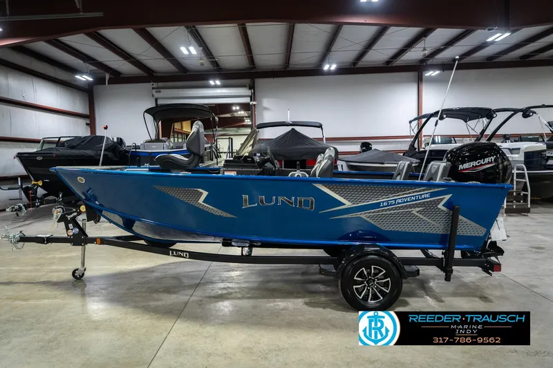Slide: The Image of 2026 Lund 1675 Adventure SS boat in showroom, blue exterior, on trailer. - 9