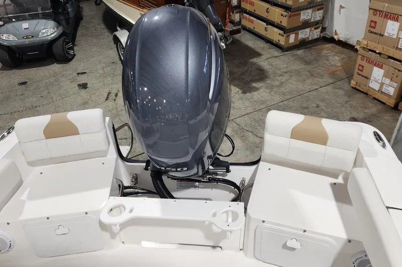 Slide: The Image of 2024 Edgewater 188CC boat interior with motor, white seating, and storage compartments. - 4