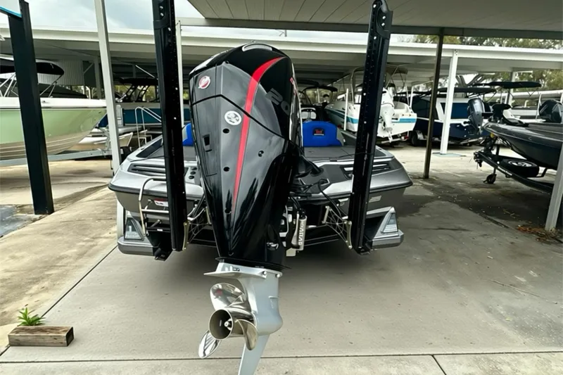 Slide: The Image of 2026 Ranger Z518 boat with powerful outboard motor, parked in a covered marina. - 16