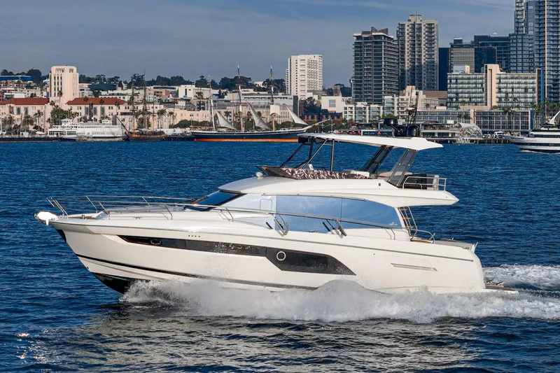 Slide: The Image of 2023 Prestige 520 yacht cruising near city skyline, showcasing luxury and modern design. - 12