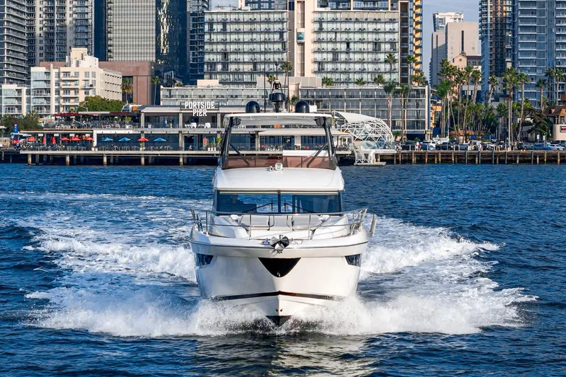 Slide: The Image of 2023 Prestige 520 yacht cruising in urban waterfront setting. - 22