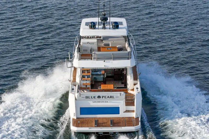 Slide: The Image of 2023 Prestige 520 yacht cruising on open water, rear view. - 26