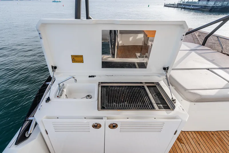 Slide: The Image of Outdoor kitchen on 2023 Prestige 520 yacht with grill and sink, overlooking water. - 31