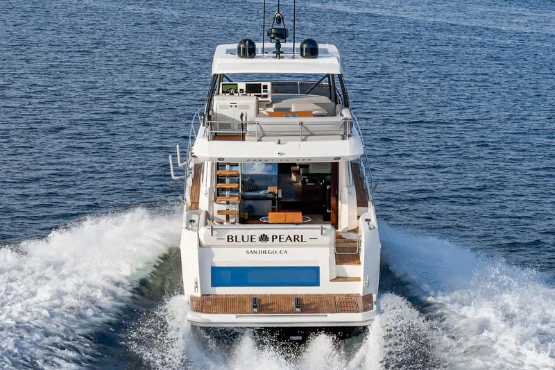 Slide: The Image of 2023 Prestige 520 yacht "Blue Pearl" cruising in open water, rear view. - 33