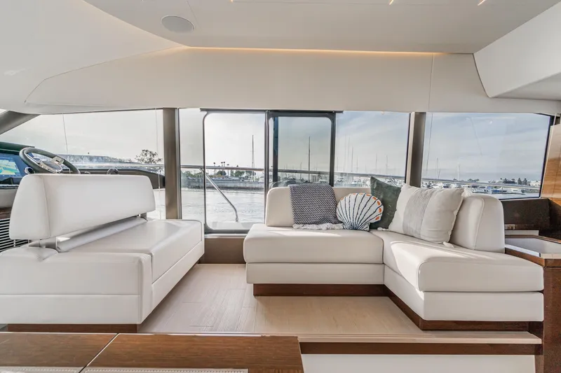 Slide: The Image of Luxurious interior of 2023 Prestige 520 yacht with elegant white seating and scenic window views. - 46
