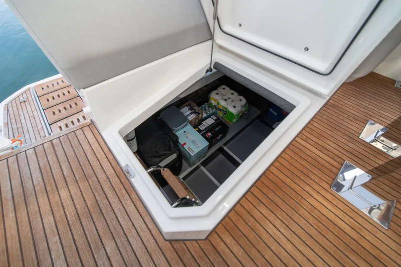 Slide: The Image of Storage compartment on 2023 Prestige 520 yacht with supplies and wooden deck. - 69