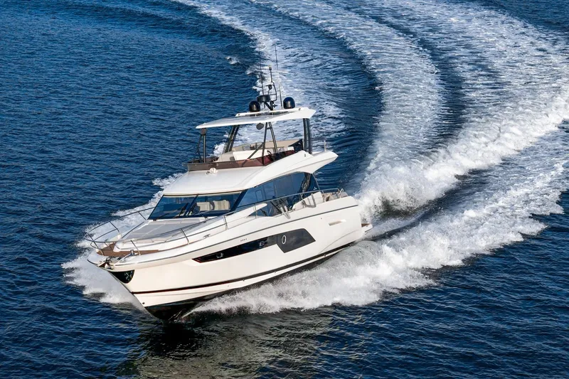 Slide: The Image of 2023 Prestige 520 yacht cruising on open water, creating dynamic waves. - 7