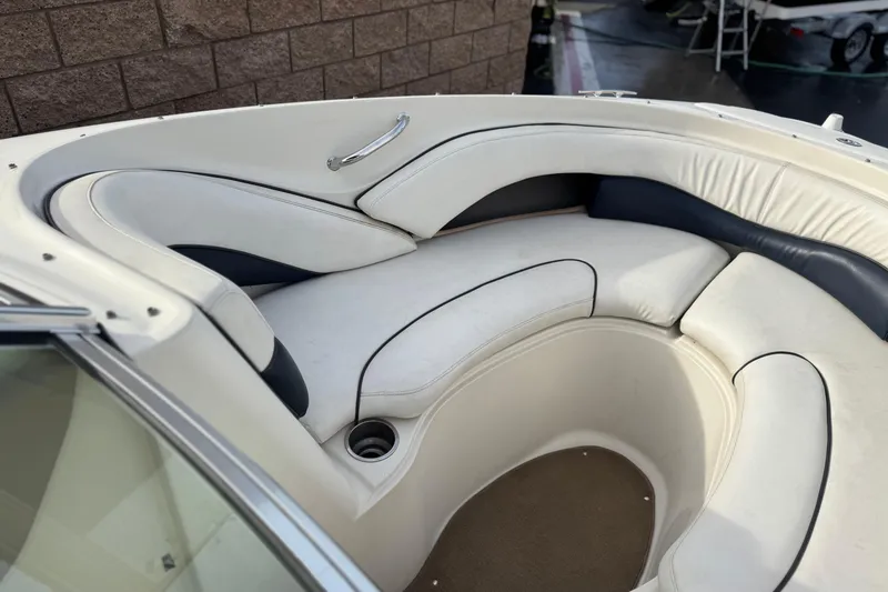 Slide: The Image of 2006 Sea Ray 220 Select boat interior with white cushioned seating and cup holder. - 12