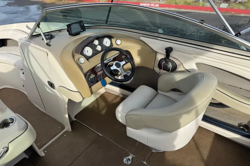 Slide: The Image of Interior of a 2006 Sea Ray 220 Select boat, featuring steering wheel and dashboard controls. - 24