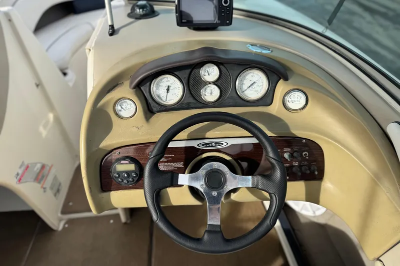 Slide: The Image of Steering wheel and dashboard of 2006 Sea Ray 220 Select boat with gauges and controls. - 25