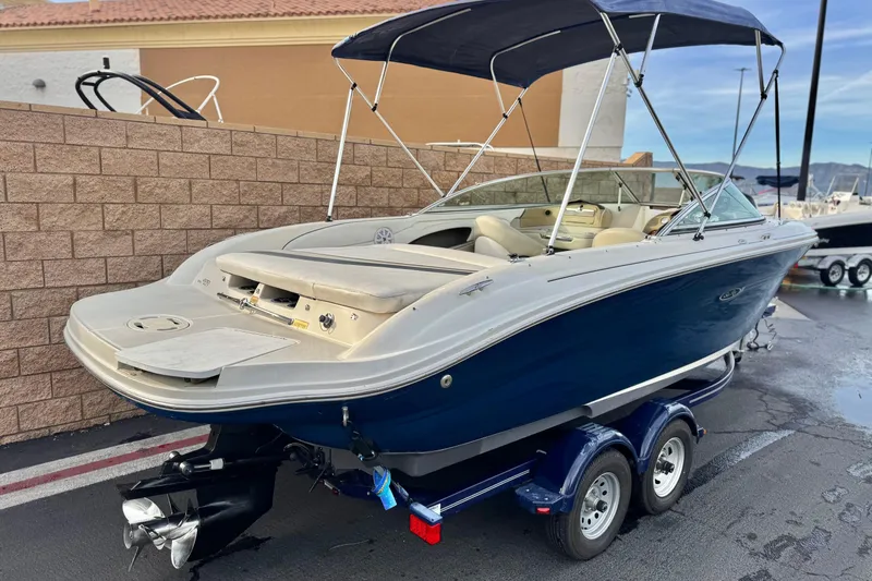 Slide: The Image of 2006 Sea Ray 220 Select boat with blue hull and bimini top on trailer. - 5