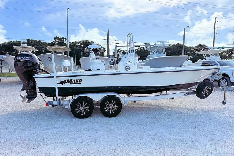 The Image of 2019 Mako 21 LTS boat on trailer, parked outdoors with other boats. - 1