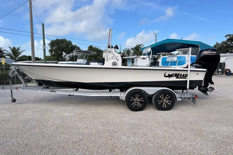 Slide: The Image of 2019 Mako 21 LTS boat on trailer, parked outdoors under blue sky. - 4
