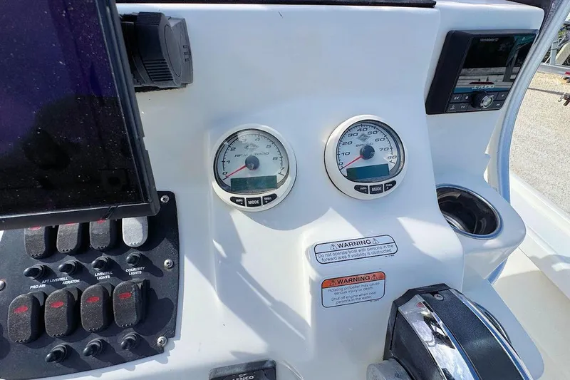 Slide: The Image of 2019 Mako 21 LTS boat dashboard with gauges, controls, and warning labels. - 9