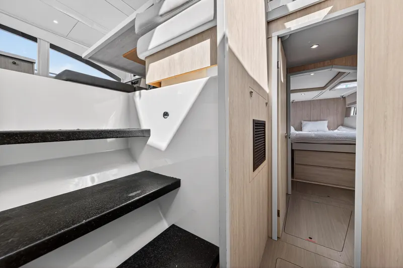 Slide: The Image of Interior of 2016 Leopard 51 Powercat, featuring stairs and a cozy bedroom. - 105
