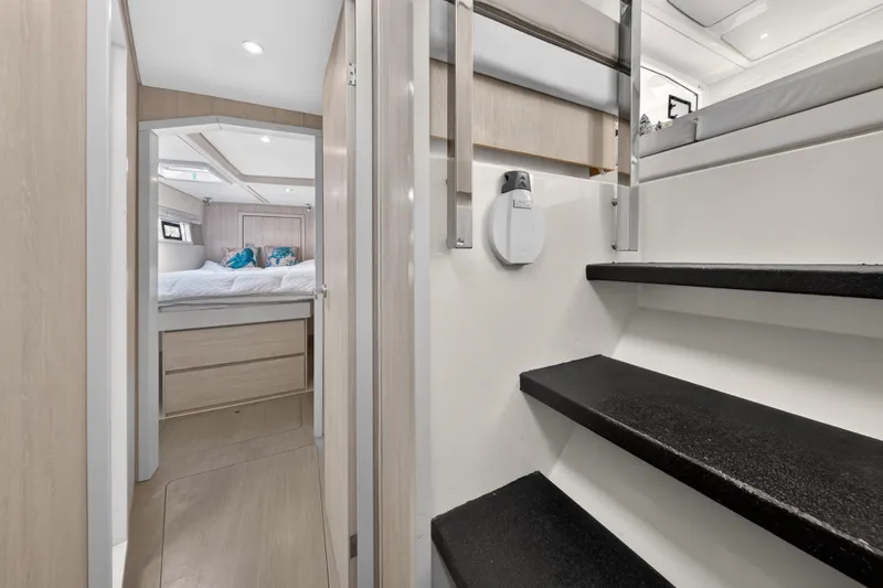 Slide: The Image of Interior of 2016 Leopard 51 Powercat, featuring stairs and a cozy bedroom. - 113