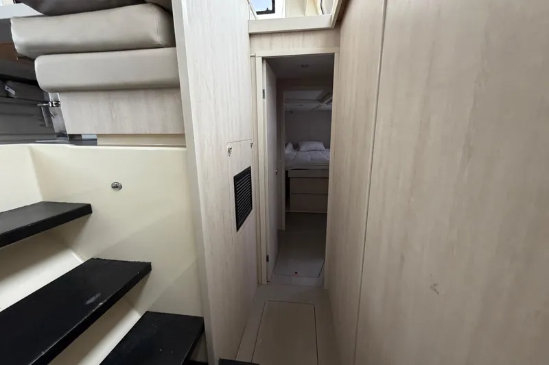 Slide: The Image of Interior of 2016 Leopard 51 Powercat yacht, featuring stairs and a cozy cabin hallway. - 20