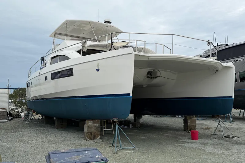 Slide: The Image of 2016 Leopard 51 Powercat catamaran on dry dock, showcasing sleek design and spacious deck. - 31