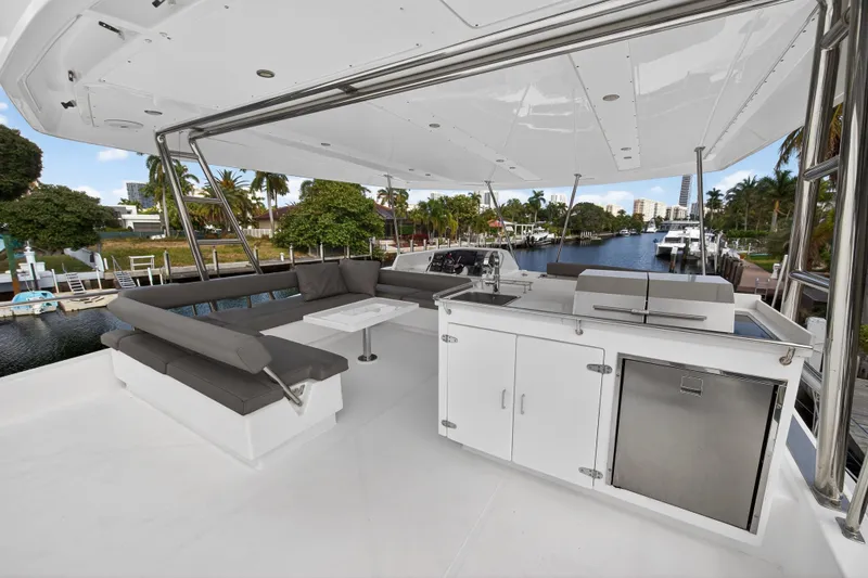 Slide: The Image of Spacious deck of 2016 Leopard 51 Powercat with seating and kitchenette, docked by a scenic canal. - 42