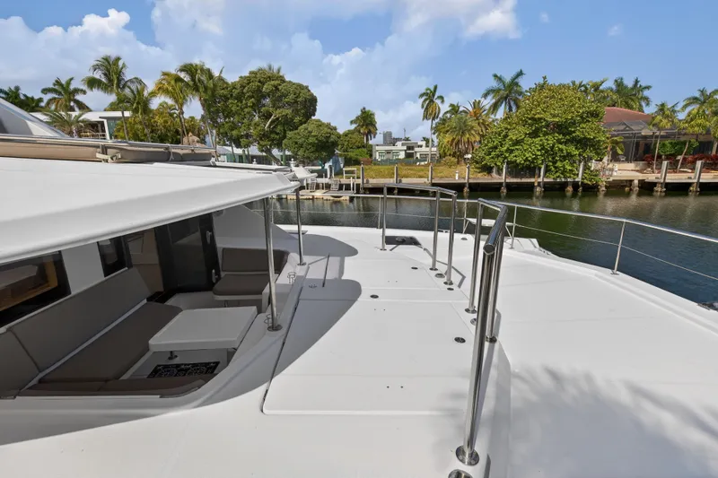 Slide: The Image of 2016 Leopard 51 Powercat yacht docked by a scenic waterfront with lush greenery. - 50