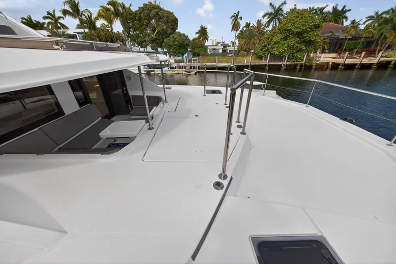 Slide: The Image of 2016 Leopard 51 Powercat yacht deck with seating, docked by lush greenery. - 55