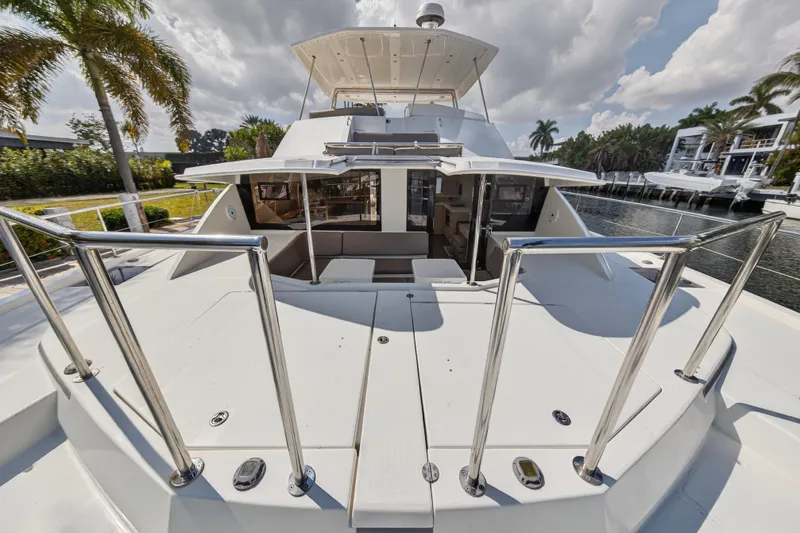 Slide: The Image of 2016 Leopard 51 Powercat yacht docked, featuring spacious deck and modern design under cloudy skies. - 64