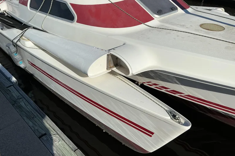 Slide: The Image of 1992 Dragonfly 800 Swing Wing trimaran with red accents docked at marina. - 2