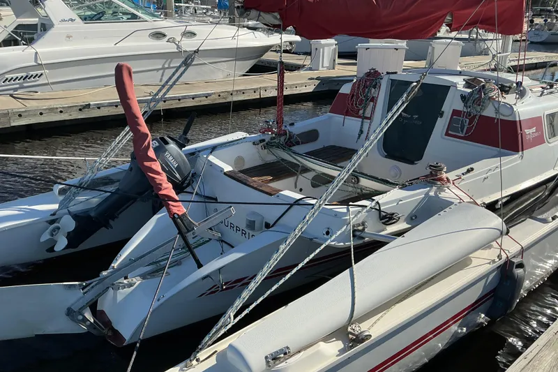 Slide: The Image of 1992 Dragonfly 800 Swing Wing trimaran docked at marina with Yamaha outboard motor. - 26