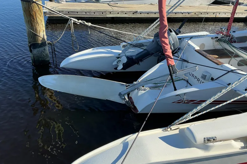 Slide: The Image of 1992 Dragonfly 800 Swing Wing trimaran docked with outboard motor and folded amas. - 27