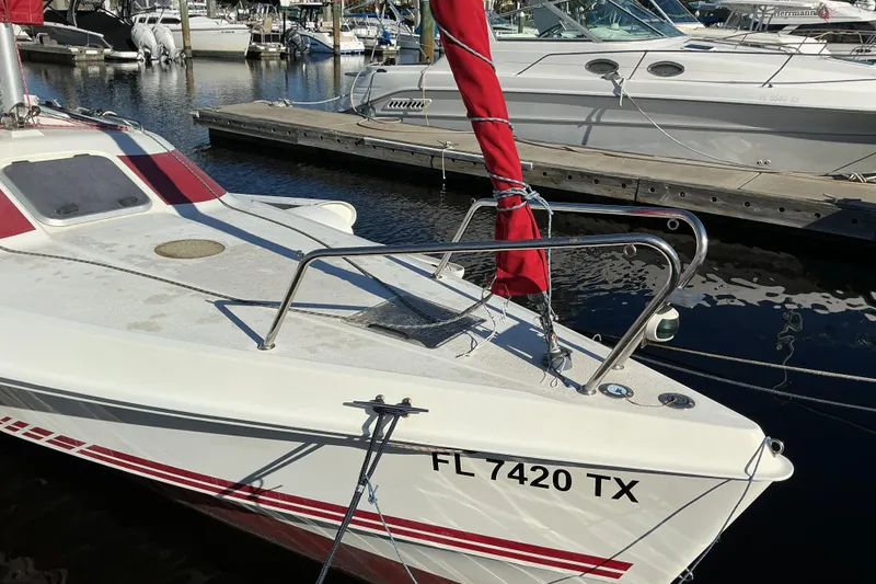 Slide: The Image of 1992 Dragonfly 800 Swing Wing sailboat docked at marina, featuring red accents. - 3