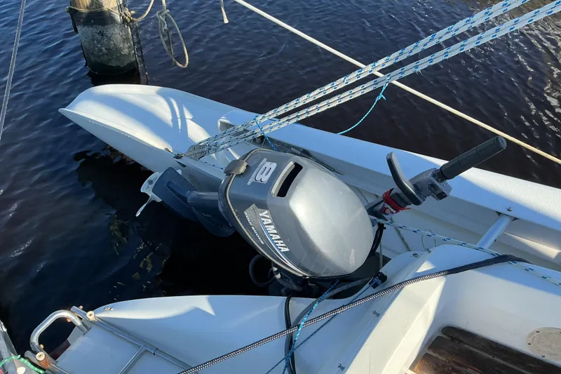 Slide: The Image of Outboard motor on 1992 Dragonfly 800 Swing Wing sailboat, docked on calm water. - 30
