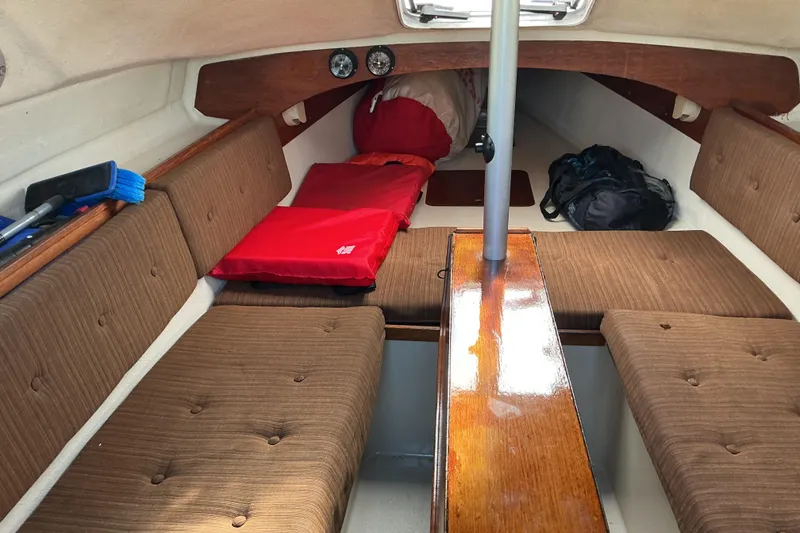 Slide: The Image of Interior of a 1992 Dragonfly 800 Swing Wing sailboat with brown cushions and red bedding. - 31