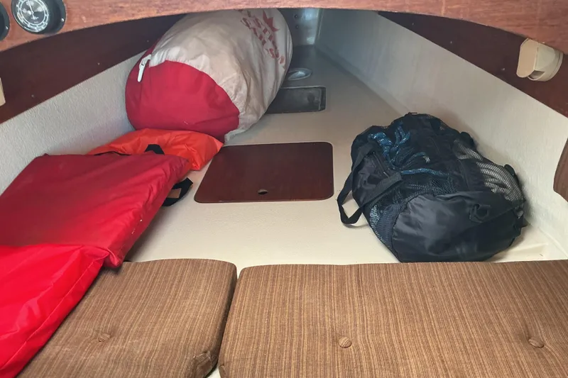 Slide: The Image of Interior cabin of 1992 Dragonfly 800 Swing Wing sailboat with cushions and gear bags. - 32