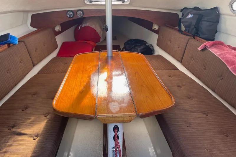 Slide: The Image of Cozy cabin interior of 1992 Dragonfly 800 Swing Wing sailboat with wooden table and cushioned seating. - 4