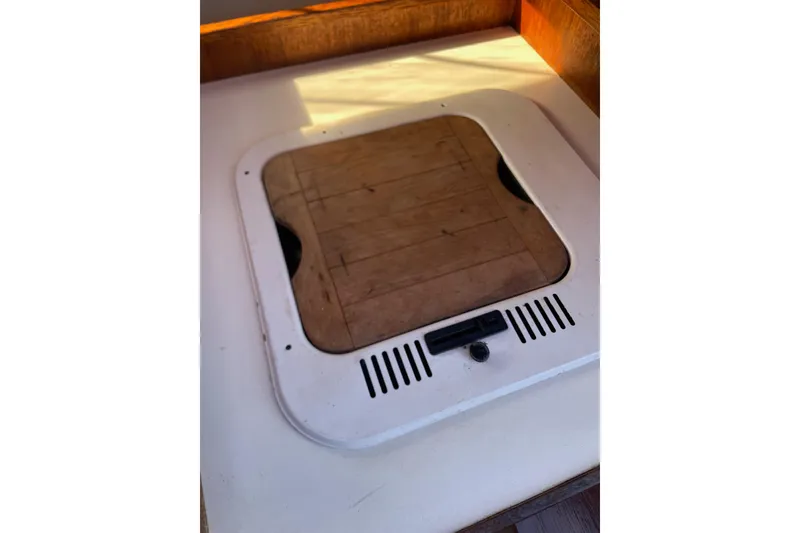 Slide: The Image of Hatch cover on a 1992 Dragonfly 800 Swing Wing sailboat, featuring a wooden insert. - 52