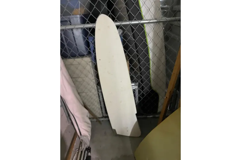 Slide: The Image of White wing panel from a 1992 Dragonfly 800 Swing Wing, leaning against a chain-link fence. - 68