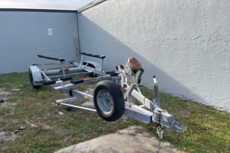 Slide: The Image of Trailer parked on grass, Dragonfly 800 Swing Wing model, 1992, near a gray wall. - 69