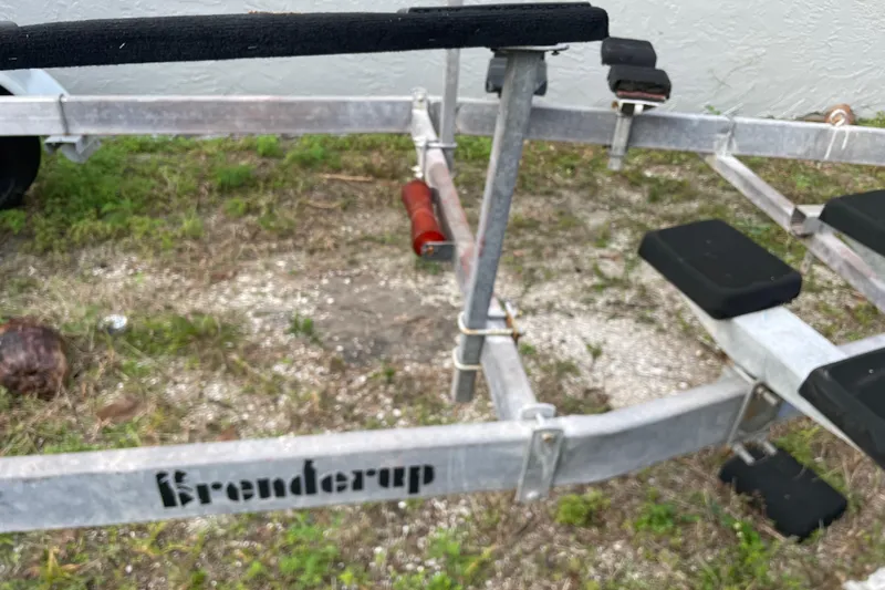Slide: The Image of Boat trailer frame on grass, featuring Krenderup branding, 1992 Dragonfly 800 Swing Wing model. - 76