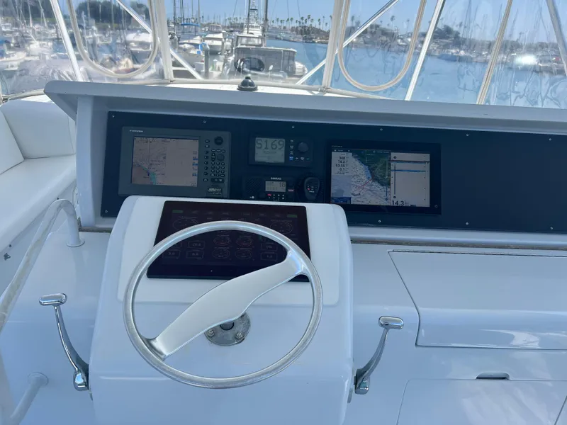 Slide: The Image of Cockpit of 2000 Hatteras 60 yacht with navigation screens and steering wheel. - 11