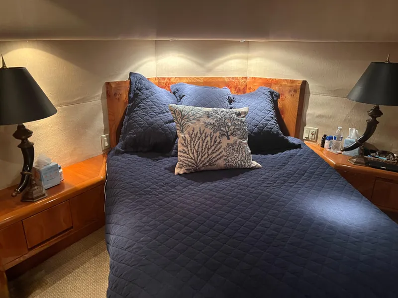 Slide: The Image of Luxurious bedroom interior of a 2000 Hatteras 60 yacht with elegant bedding and lighting. - 6