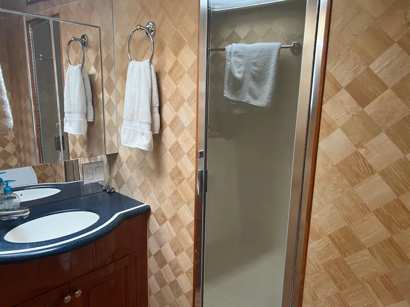 Slide: The Image of Luxurious bathroom in 2000 Hatteras 60 yacht with dual sinks and glass shower. - 7