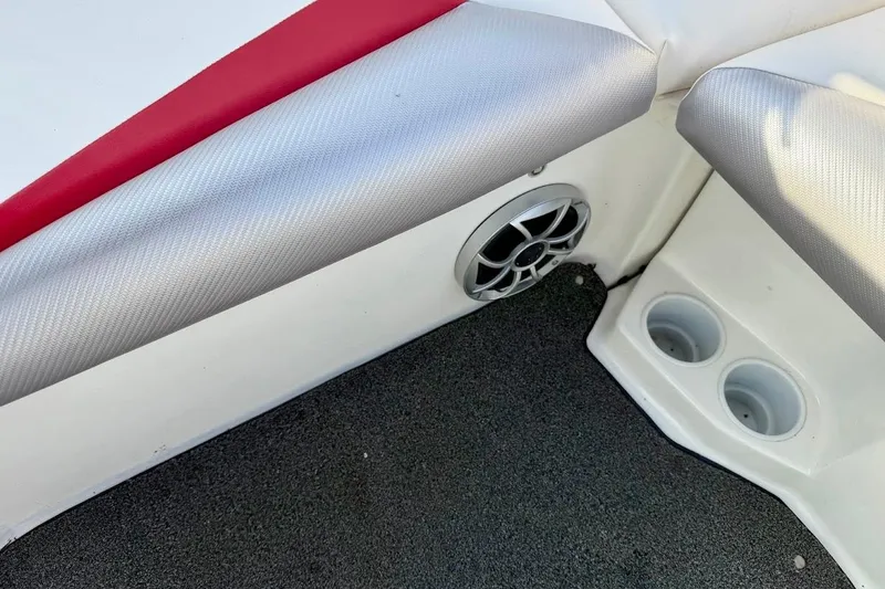 Slide: The Image of 2012 Tigé R20 boat interior with speaker and cup holders, featuring red and gray upholstery. - 30