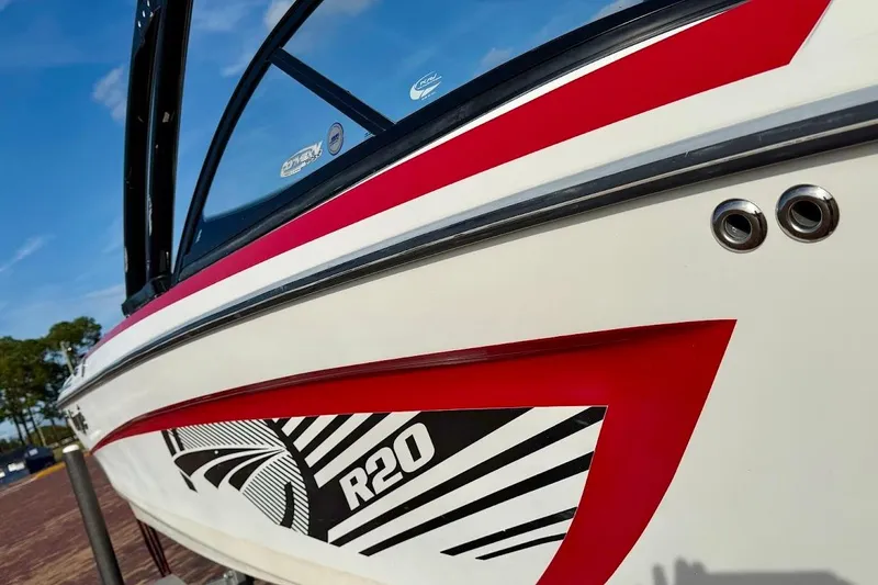 Slide: The Image of 2012 Tigé R20 boat with red and white design, close-up view. - 6
