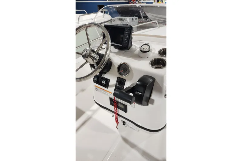 Slide: The Image of 2024 Edgewater 158CS boat console with steering wheel, controls, and navigation instruments. - 6