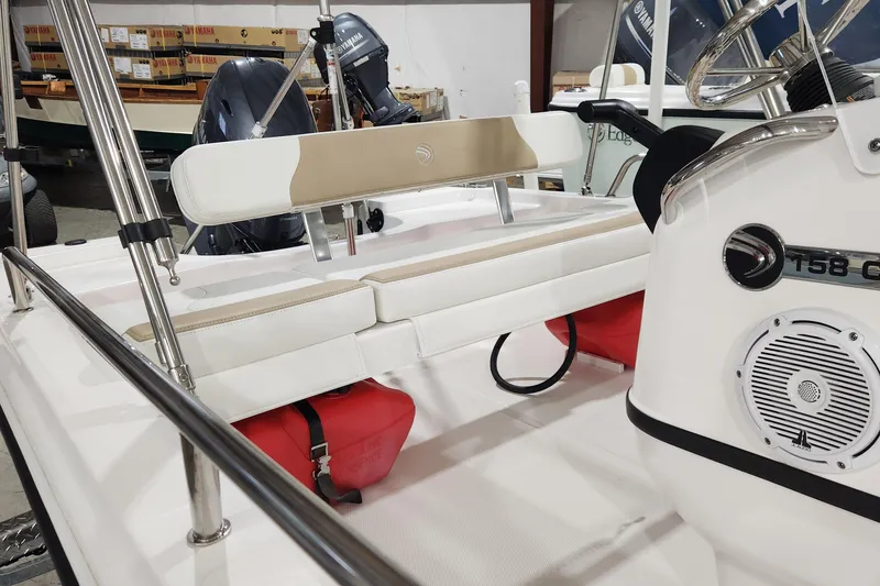 Slide: The Image of 2024 Edgewater 158CS boat interior with seating, steering wheel, and Yamaha engine in a showroom. - 9