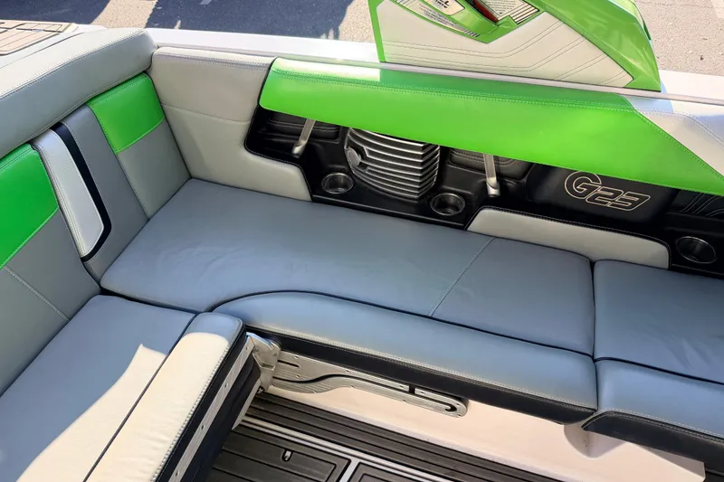 Slide: The Image of 2014 Nautique Super Air Nautique G23 interior with green and gray seating. - 15