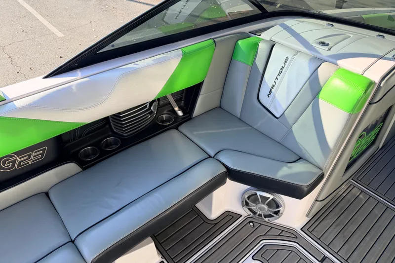 Slide: The Image of 2014 Nautique Super Air Nautique G23 interior with green and gray seating. - 16