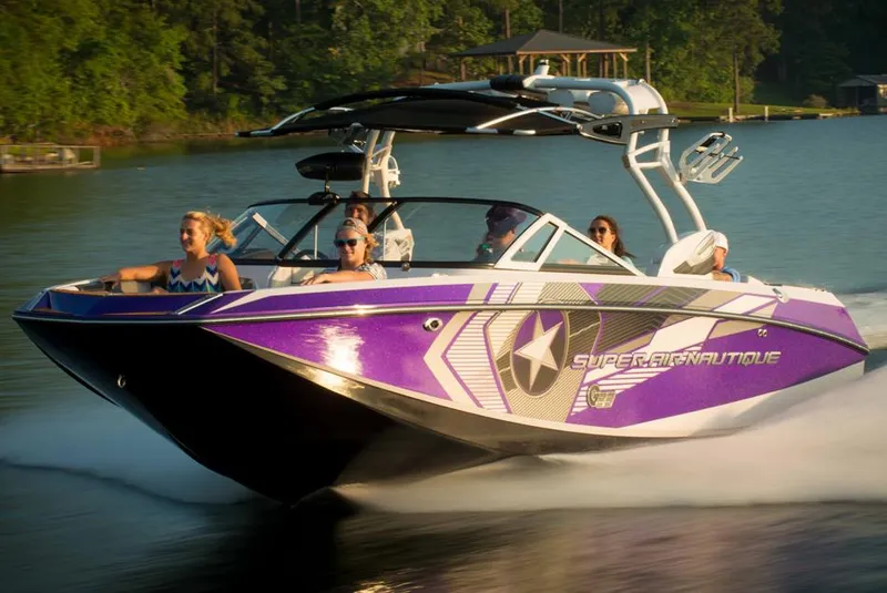 Slide: The Image of 2014 Nautique Super Air Nautique G23 boat, vibrant green, rear view in outdoor setting. - 2