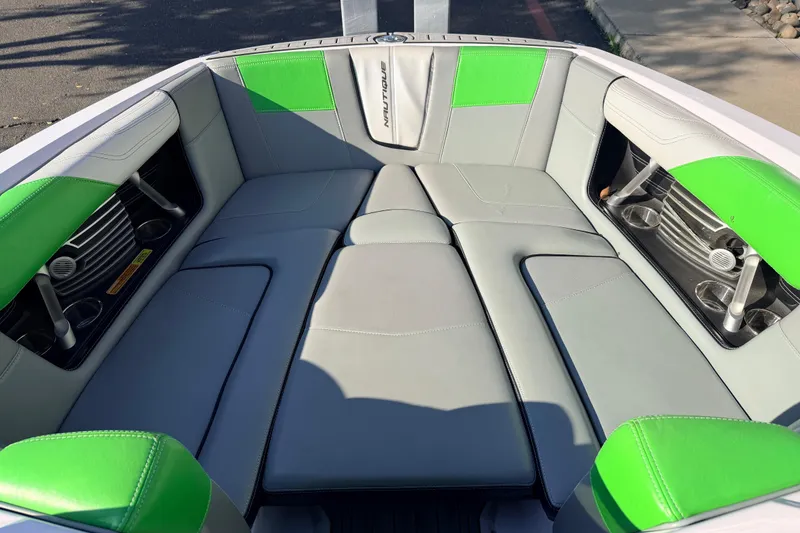 Slide: The Image of 2014 Nautique Super Air Nautique G23 boat interior with gray and green seating. - 22